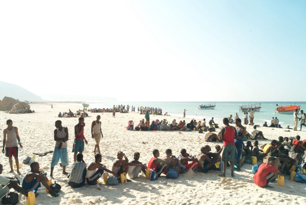 Refugees and migrants line up on a Somalia beach to board the boats that will take them across the Gulf of Aden to Yemen. In this human trafficking military style operation, the passengers board the small smugglers’ boats in groups of 10. The overcrowded boats can take days to cross. Photo Credit: UNHCR/Alixandra Fazzina